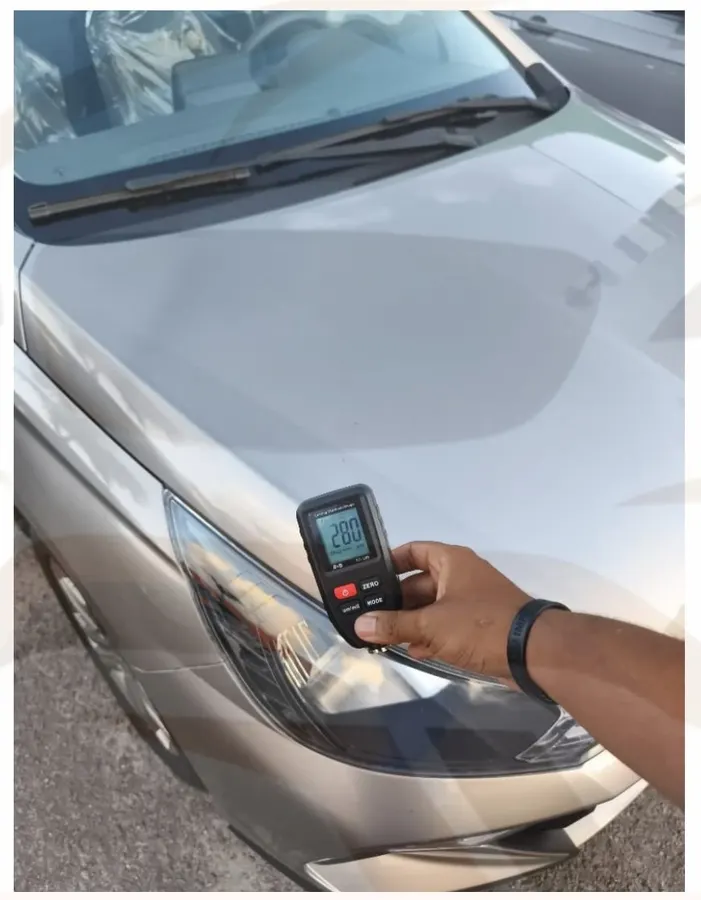 Medição de pintura perto do farol de um carro prata